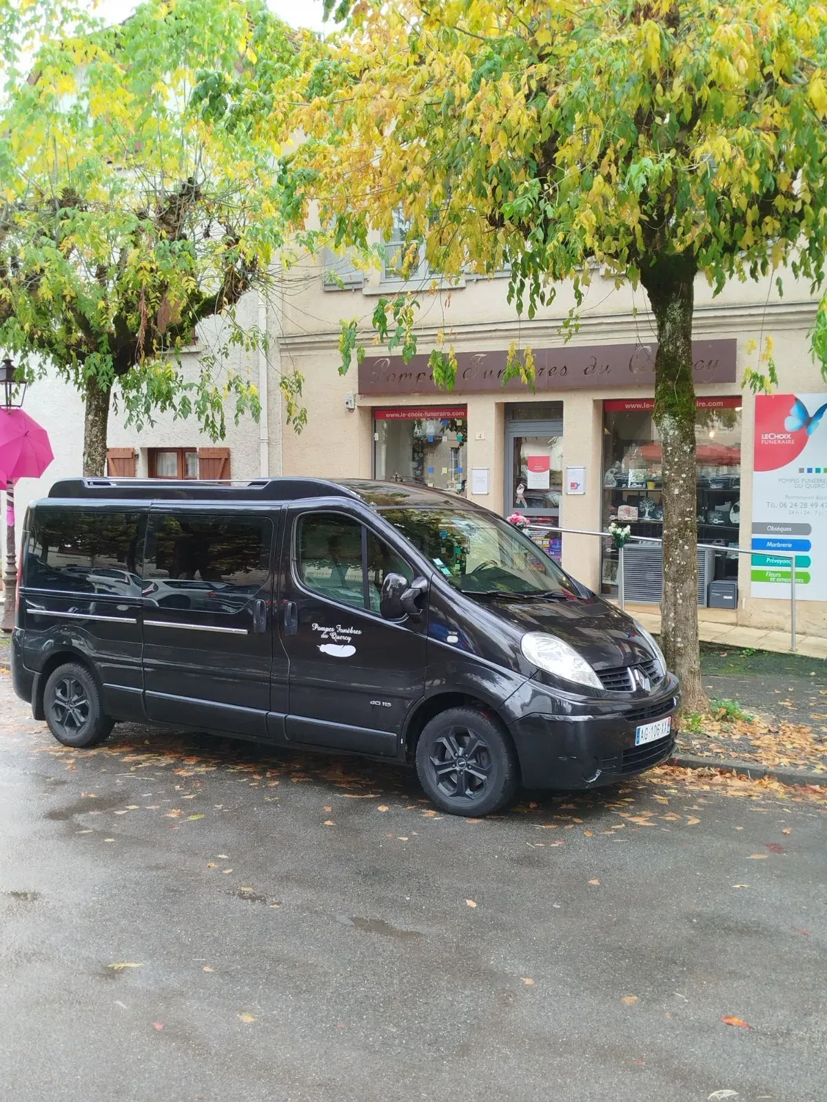 Corbillard noir stationné devant l'agence des pompes funèbres.