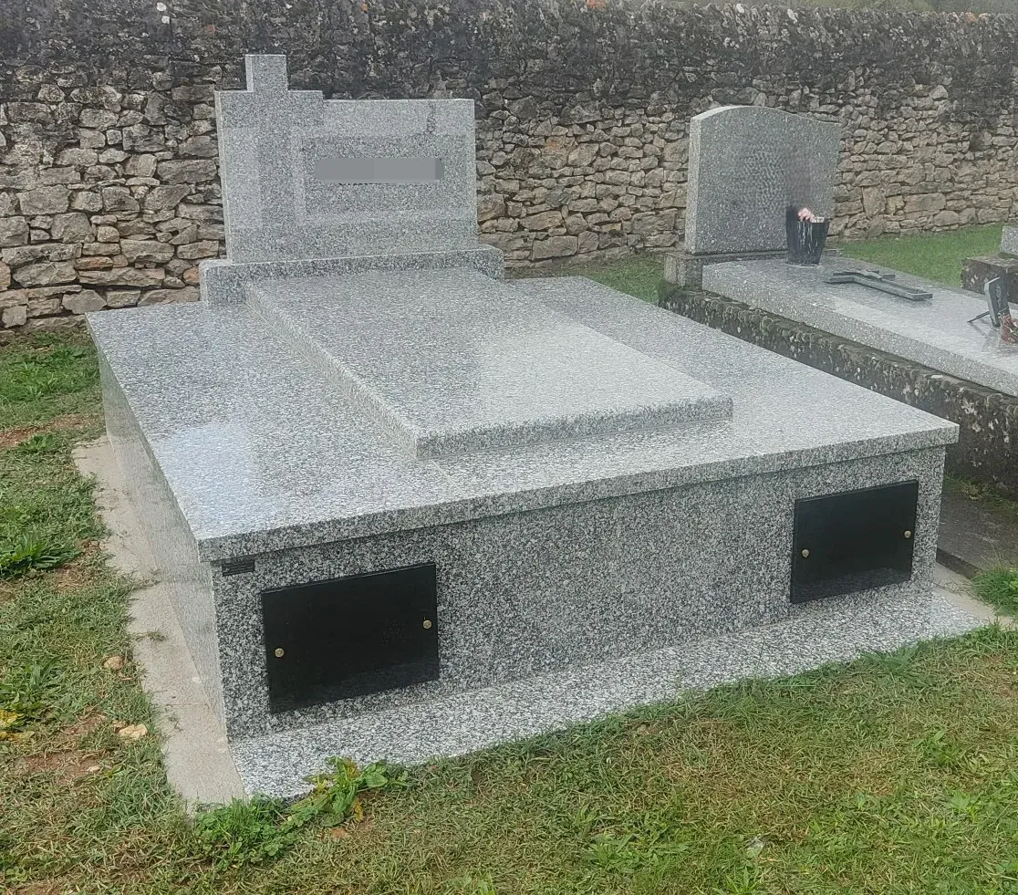 Caveau familial en granite clair installé dans un cimetière.